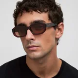 Lentes de sol con montura geométrica de color bordó translúcido y cristales polarizados en tono marrón. Diseño moderno y actual con acabado resistente a rayaduras.