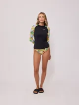 Remera de natación manga larga con protección UV, cuerpo en color negro y mangas con estampado floral tropical. Presenta cuello redondo y logo de la marca estampado en el pecho.
