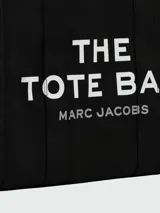Bolso tote de gran tamaño en color negro, confeccionado en lona resistente. Presenta el logo distintivo de la marca estampado en blanco en el frente y doble asa superior para llevar al hombro.