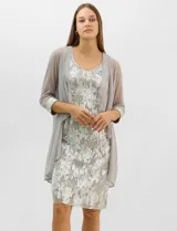 Conjunto de dos piezas compuesto por un vestido midi de silueta recta con tejido plisado metalizado y escote redondo con pedrería, acompañado por una chaqueta de gasa abierta con caída en cascada y mangas tres cuartos con puños metalizados.