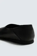 Mocasín de piel color negro con construcción desestructurada que permite usarlo como zapato destalonado. Cuenta con horma redonda, forro y plantilla de piel, y suela de goma VIBRAM®.
