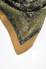 Pañuelo de forma cuadrada con estampado paisley en tonos verdes, tostados y marrones, con bordes en tono mostaza.