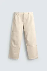 Pantalón relaxed fit color beige, confeccionado en tejido de algodón. Cuenta con bolsillos frontales, bolsillos traseros de plastrón y aplicación de bolsillos plastrón con tira multifunción en la pernera. Cierre frontal con cremallera y botón.