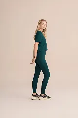 Calza deportiva larga color verde oscuro, de tiro alto y corte ajustado, con bolsillos laterales.