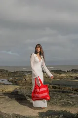 Bolso tipo tote tejido a crochet con hilo de algodón color marrón y crudo, con diseño a rayas horizontales y volados en los bordes.