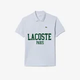 Remera polo de piqué de algodón orgánico color celeste con cuello y mangas acanaladas, cierre frontal con botones de nácar y estampa frontal de la marca con diseño tipográfico en verde. Cuenta con el clásico cocodrilo bordado en el pecho.
