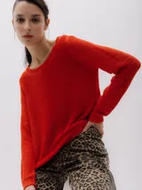 Sweater de punto color rojo arcilla, con cuello redondo y mangas largas, de diseño clásico y ajuste recto.