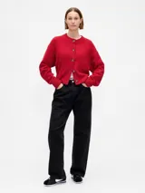 Saco tipo cardigan de punto color rojo, con cuello redondo, cierre frontal de botones y mangas largas con puños acanalados.