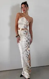 Vestido midi con estampado de cebra, corte ajustado y escote halter. Incluye cinturón dorado.