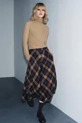 Falda midi de tiro medio con estampado de cuadros en tonos azul marino, marrón y beige. Confeccionada en hilatura con mezcla de viscosa, presenta un bajo acabado en línea evasé y cierre con cremallera oculta en la costura.