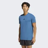 Remera de entrenamiento Adidas con tecnología AEROREADY para absorción de humedad. Presenta cuello redondo, ajuste ceñido, cortes en los dobladillos laterales y dobladillo trasero ligeramente más largo. Incluye el logo de la marca estampado en el centro del pecho.