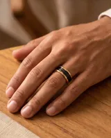 Anillo de acero con banda central ancha color negro y bordes con baño de oro.