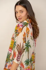Camisa oversize de lino color crudo, con cuello camisero y estampado multicolor de paisajes tropicales con palmeras y arquitectura.