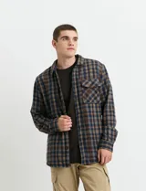 Sobrecamisa de manga larga con diseño a cuadros, cuello camisero y bolsillos laterales. Presenta un interior forrado con textura símil corderito y cierre frontal con botones.