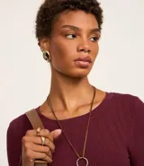 Suéter de punto acanalado color beige, con cuello redondo y mangas largas. Confeccionado en tejido tricot con textura suave y ajuste al cuerpo.