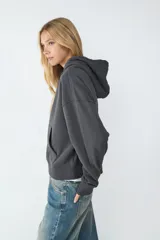 Buzo con capucha ajustable mediante cordón y bolsillo tipo canguro. Presenta mangas largas, puños y ruedo acanalados.