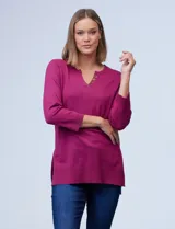 Buzo tejido de hilado fino color fucsia, marca Cable & Gauge. Cuello con solapa, escote en V con aplique de botones metálicos. Manga larga amplia con puño elastizado y laterales con tajo.