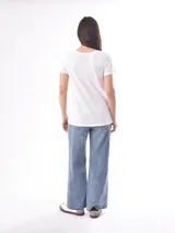 Remera blanca de manga corta con escote en V, de tejido ligero y ligeramente traslúcido.