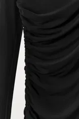 Vestido largo negro de manga larga confeccionado en mezcla de viscosa. Presenta cuello amplio multiposición y detalle de drapeado fruncido en el lateral del torso.