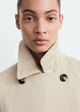 Trench coat de corte recto y diseño oversize, con cierre de doble botonadura, cuello de solapa ancha, bolsillos laterales y mangas largas con puños abotonados. Incluye cinturón desmontable y forro interior.