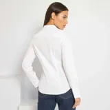 Camisa blanca de corte ajustado con cuello italiano y mangas largas.