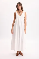 Vestido largo blanco sin mangas, con escote en V y pinza frontal que aporta un diseño de caída suelta.