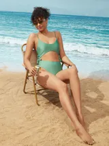 Malla entera color verde con abertura en la zona abdominal y lazos laterales.