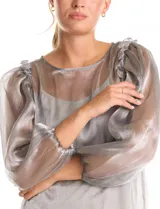 Blusa de organza translúcida con acabado satinado, mangas estilo balloon con volados en los hombros y puños elastizados. Incluye musculosa interna a tono.