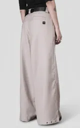 Pantalón sastrero de corte oversize en color beige, confeccionado en tejido premium con estructura. Presenta pinzas frontales profundas que aportan volumen, cintura ancha con presillas, bolsillos laterales y bolsillos traseros tipo ojal.