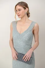 Vestido largo de tul color verde agua, enteramente bordado con lentejuelas, con escote en V cruzado y corte imperio.