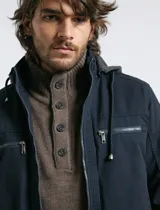 Campera técnica de tejido elástico en color azul marino, con capucha ajustable, cierre frontal y bolsillos laterales con cierre. Cuenta con forro interior de micro polar y ajuste en el ruedo.