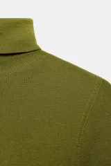 Jersey de cuello alto y manga larga, confeccionado en tejido de lana extrafina de textura suave y acabado liso.