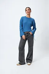 Jean recto de tiro bajo, confeccionado en denim 100% algodón, con efecto gastado y dobladillo deshilachado.