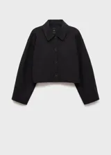 Chaqueta corta de corte recto con cuello camisero, cierre frontal de botones y dos bolsillos de parche laterales. Presenta mangas largas y forro interior.