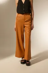 Pantalon de tiro alto confeccionado en eco-cuero, con diseño de pierna ancha y corte recto.