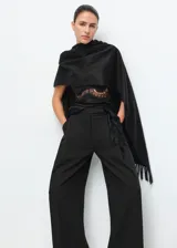 Pantalón de vestir negro de corte recto y tiro medio, con bolsillos laterales y diseño amplio.