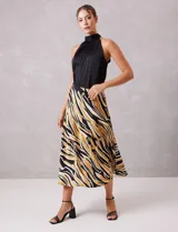 Falda midi de satén con estampado tribal en tonos negro, beige y mostaza. Presenta un corte fluido y cintura elastizada para mayor comodidad.