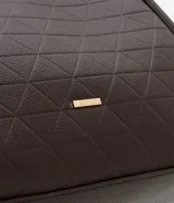 Cartera modelo hobo de gran tamaño, confeccionada en poliuretano con textura geométrica triangular. Presenta asas tubulares largas para llevar al hombro, cierre superior con cremallera y un pequeño aplique metálico dorado en la parte frontal.