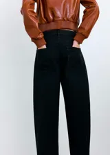 Jeans de corte wide leg y tiro medio de color negro, con diseño clásico de cinco bolsillos y presillas para cinturón.