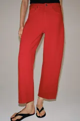 Jeans de tiro medio y corte relaxed en color rojo, con diseño de cinco bolsillos y costuras verticales en el frente.