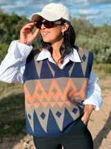 Chaleco tejido de punto con cuello en V, diseño de rombos en tonos azul marino, gris y naranja.