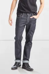 Jean de corte slim fit, color azul oscuro con costuras en contraste. Presenta diseño de cinco bolsillos, cierre frontal con cremallera y botón metálico.