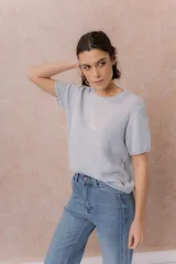 Sweater tejido celeste de manga corta con textura y delicadas líneas horizontales en relieve. Presenta cuello redondo y calce amplio con hombros caídos.