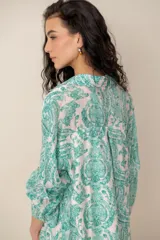 Vestido midi verde con estampado de arabescos, cuello camisero con escote en V y cierre frontal parcial de botones, de manga corta y corte recto.