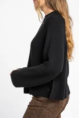 Sweater negro de punto con cuello redondo y mangas largas.