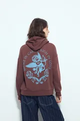 Buzo canguro color marrón con capucha y estampado de un corazón anatómico en azul en el pecho. De silueta relajada y calce cómodo.