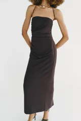 Vestido midi de escote recto con cuello halter y aplicación metálica tipo choker. Presenta frunces laterales en el delantero, abertura en la espalda y cierre con cremallera oculta.