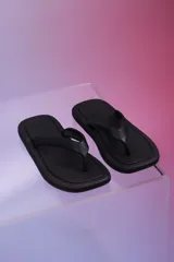 Sandalia de baño tipo ojota, color negro, de diseño minimalista con plataforma sutil y puntera cuadrada.