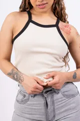 Top de rib con lycra, de corte ajustado y diseño sin mangas con cuello redondo y ribetes en contraste color negro.