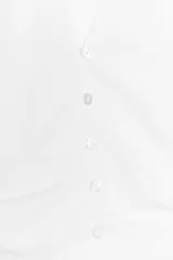 Top negro con cuello halter, escote pico y espalda descubierta. Presenta detalle de frunces laterales y cierre frontal con botones.